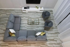 A modern living room with a grey sectional sofa, a glass coffee table, and a white entertainment unit. - Themed 5Bd Home, Movie and Game Room (4726) (Kissimmee)