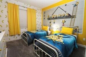A bedroom with two beds, yellow curtains, and a wall with minion-themed decorations. - Themed 5Bd Home, Movie and Game Room (4726) (Kissimmee)