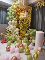 Una habitación con una bola de discoteca, globos y un cartel que dice 'Feliz Cumpleaños'.