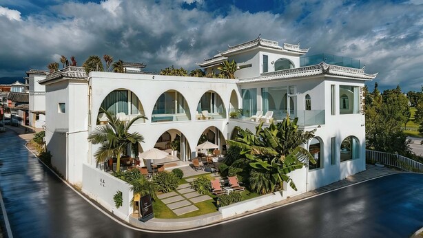 Ein modernes Gebäude im traditionellen Baustil, mit zahlreichen Rundbogenfenstern und einem Balkon.