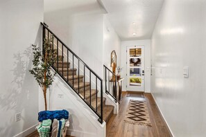 A hallway with a staircase, a door with a view, and a plant. - Skyline 1686, Hot Tub, Garage Game Room, Wii, Community Amenities (Washington)