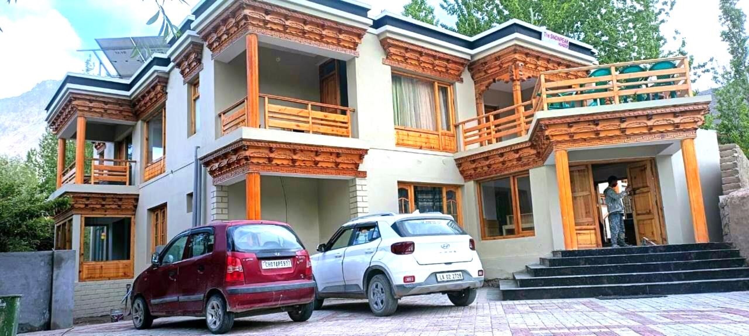 Un edificio de varios pisos con balcones de madera y una escalera que conduce a la entrada.