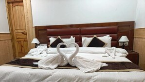 A neatly made bed with white linens and two swan-shaped towels. - The Snowpeak Hunder (Hunder)