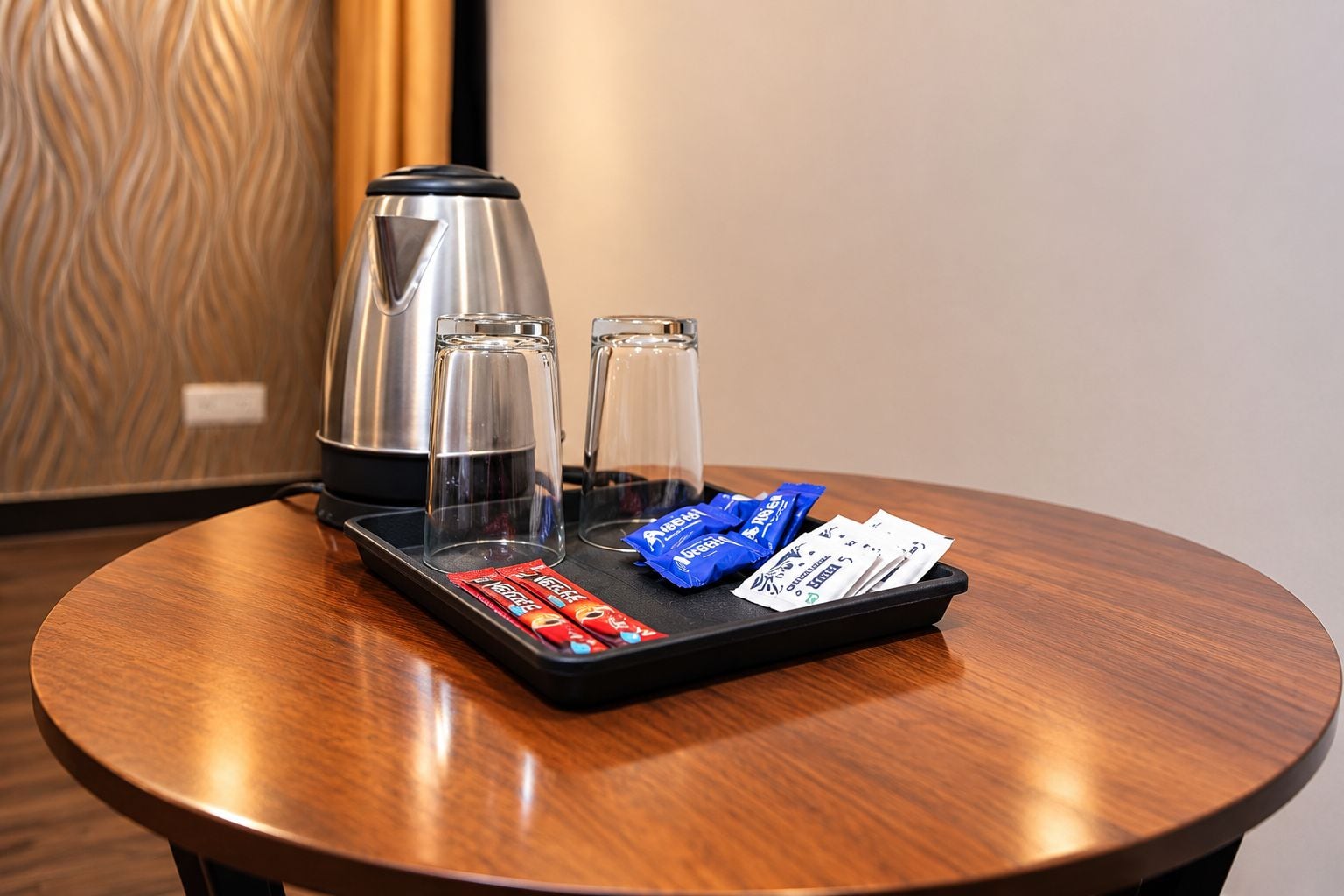 Ein runder Holztisch mit einer Ablage, die eine Kaffeemaschine, zwei Gläser und einige Snacks enthält.