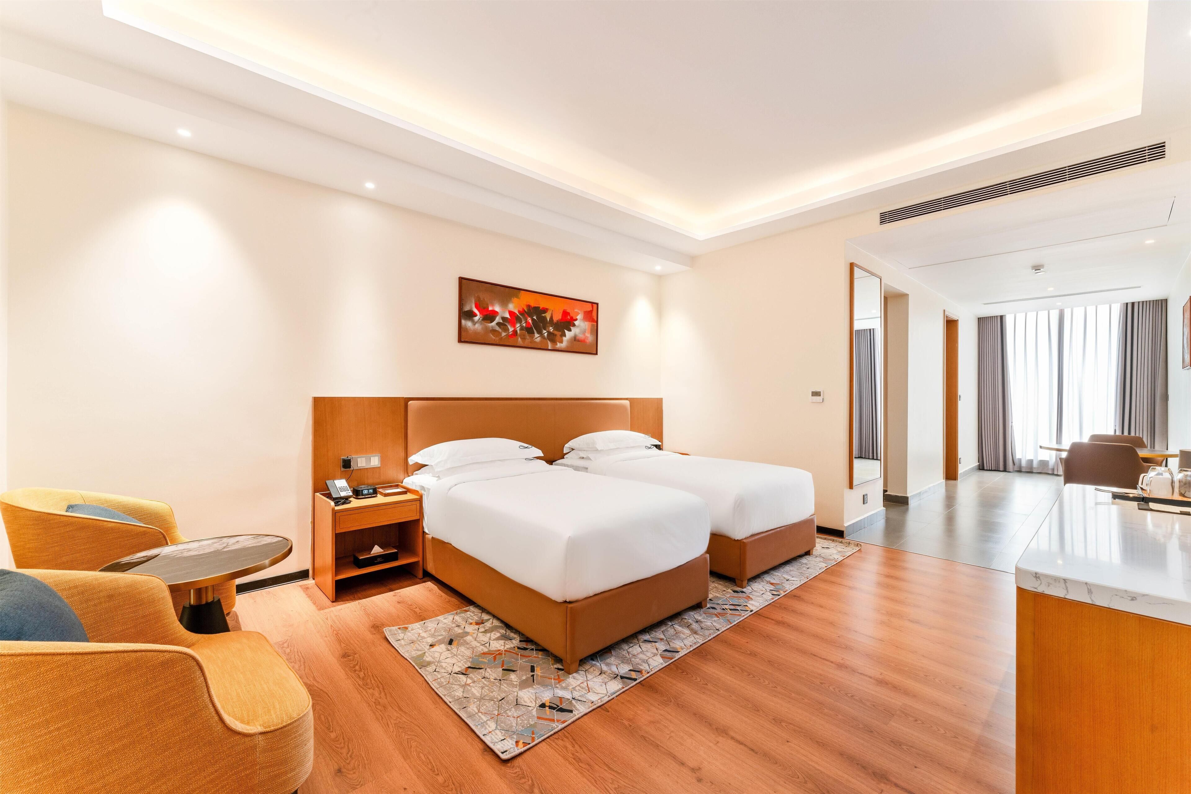 Una habitación de hotel con cama, mesita de noche, silla y escritorio.