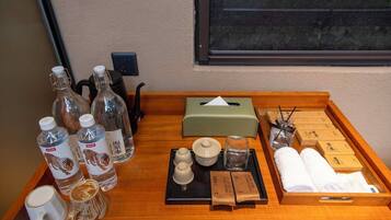 A wooden tray with various toiletries including bottles, a tissue box, and towels.