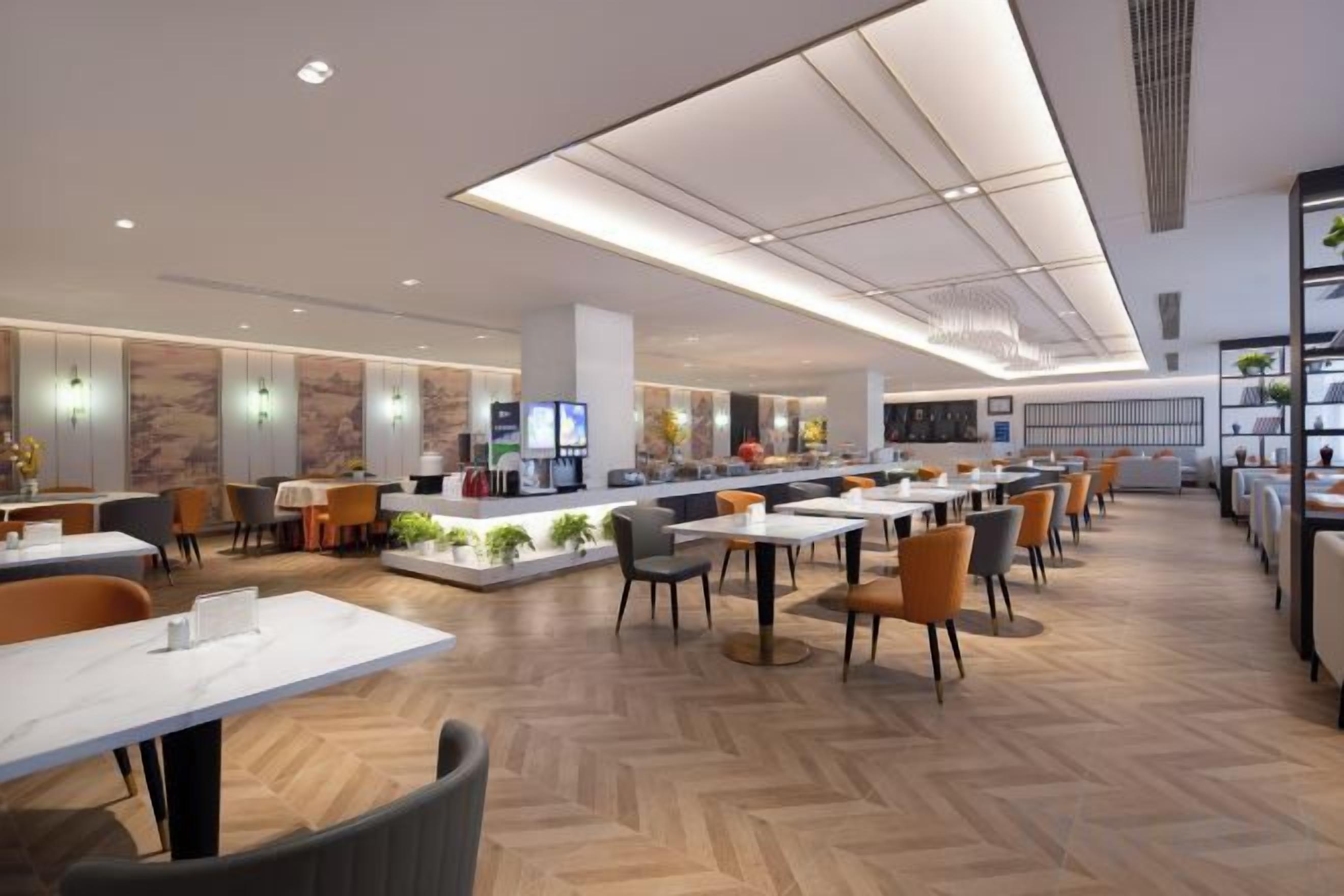 A modern hotel lobby with a central bar area, seating arrangements, and a reception desk.
