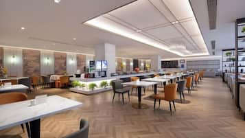 A modern hotel lobby with a central bar area, seating arrangements, and a reception desk.