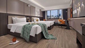 A modern hotel room with two beds, a desk, a chair, a TV, and a city view. - Hantang Hotel (Erqi Square Zhengzhou Railway Station East Square Branch) (Zhengzhou)