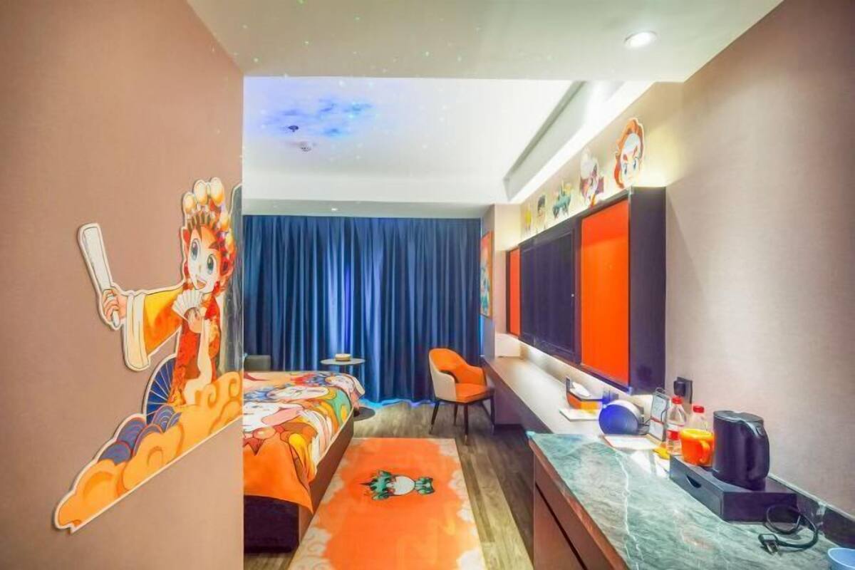 A hotel room with a bed, a desk, a chair, a television, and a wall decoration.
