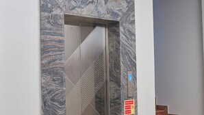 An elevator with a marble facade, a number "3" above it, and a staircase to the right. - Blue top motel mbarara (Mbarara)