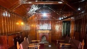 Un intérieur en bois avec une cheminée, des meubles en bois et un plafond haut.