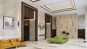 A modern lobby with a green sofa, a yellow sofa, and a reception desk. - Kotrip Luxstay River Gate Residence (Ho Chi Minh City)