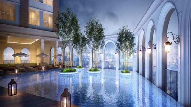 A modern hotel with a large indoor swimming pool, lounge areas, and arched windows. - Kotrip Luxstay River Gate Residence (Ho Chi Minh City)