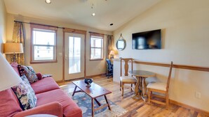 A spacious living room with a red sofa, a wooden coffee table, a dining table with chairs, and a ceiling fan. - 3 Blocks to Main St: Cozy Gunnison Retreat! (Gunnison)
