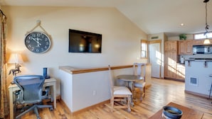 A modern kitchen with wooden cabinets, a microwave, and a dining area with a table and chairs. - 3 Blocks to Main St: Cozy Gunnison Retreat! (Gunnison)