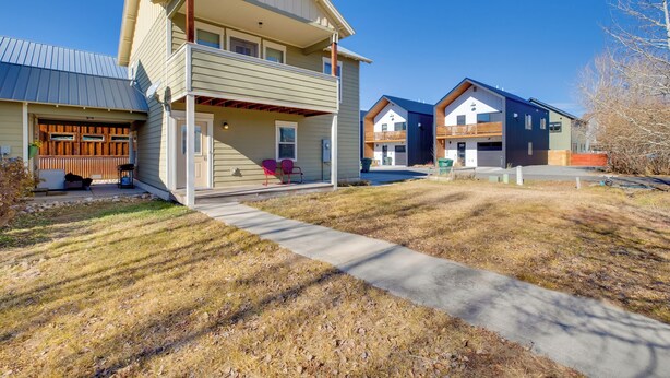 A two-story house with a covered porch, a garage, and a well-maintained lawn. - 3 Blocks to Main St: Cozy Gunnison Retreat! (Gunnison)