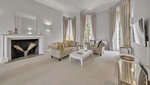 A spacious living room with a fireplace, two sofas, a coffee table, and a TV. - Hans Place Residences (London)