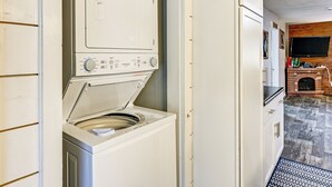 A laundry room with stacked washers and dryers, a fireplace, and a television. - 1 Mi to Lake Arbutus: Pet-Friendly Home w/ Games (Merrillan)