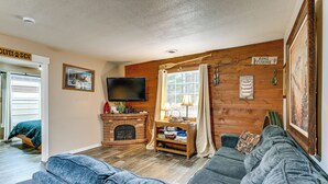 A cozy living room with a fireplace, a television, and a couch. - 1 Mi to Lake Arbutus: Pet-Friendly Home w/ Games (Merrillan)