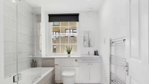 Un baño moderno con bañera, inodoro y lavamanos.