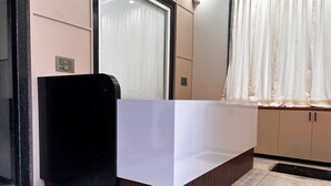 A modern reception desk with a black marble base and a white top. - Hotel Lakshya Raj Palace - Khatushyamji (Khatoo)