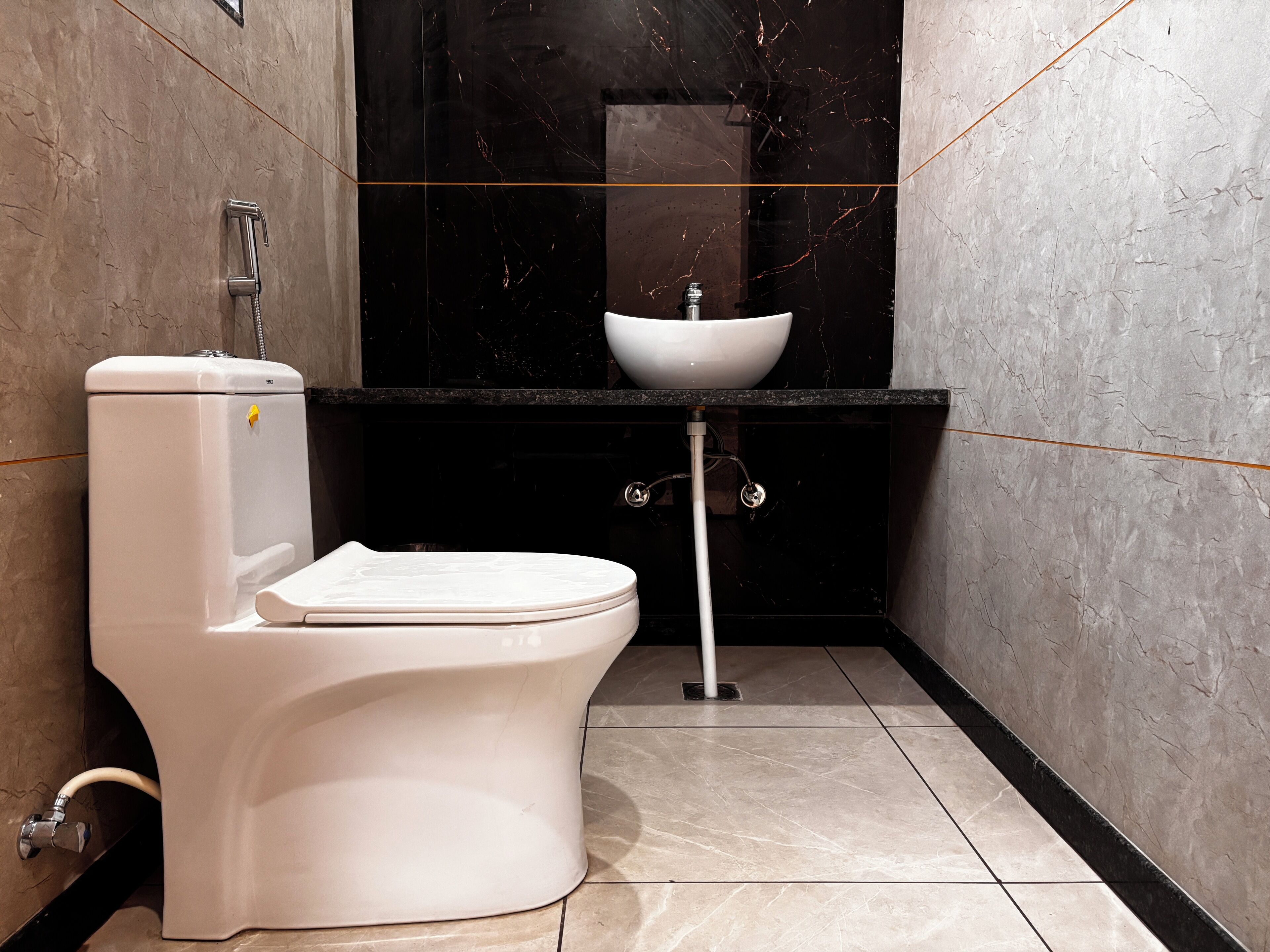 Een moderne badkamer met toilet, wastafel en douche.