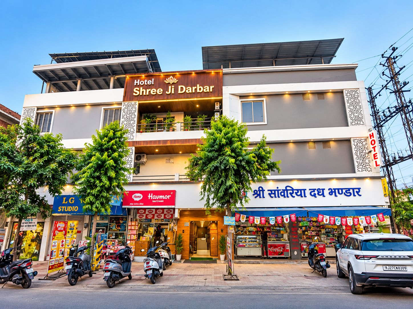 Un hotel llamado 'Hotel Shree Ji Darbar' con una fachada moderna, varios pisos y una entrada visible.