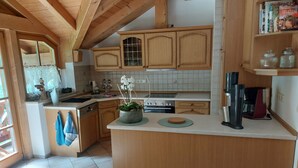 Una cocina con armarios de madera, salpicadero de azulejos y una isla central con una planta en maceta.