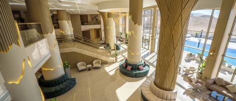 A spacious lobby with high ceilings, large columns, and a central seating area.