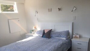 Una camera da letto con un letto, comodini, una lampada e decorazioni alle pareti.