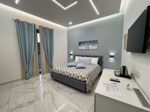 Une chambre à coucher moderne avec un lit, un bureau et un téléviseur.