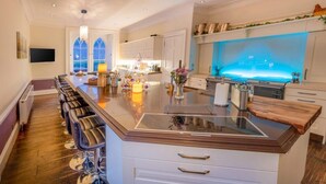 Un'ampia cucina con una grande isola, sgabelli da bar e vista sul mare attraverso una finestra.