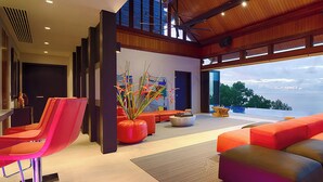 Un intérieur moderne avec une grande fenêtre, des sièges rouges et une plante décorative.