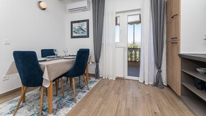 A dining area with a table set for two, two chairs, a rug, and a view of the outdoors through a door. - Stunning apartment in Silo with WiFi (Silo)