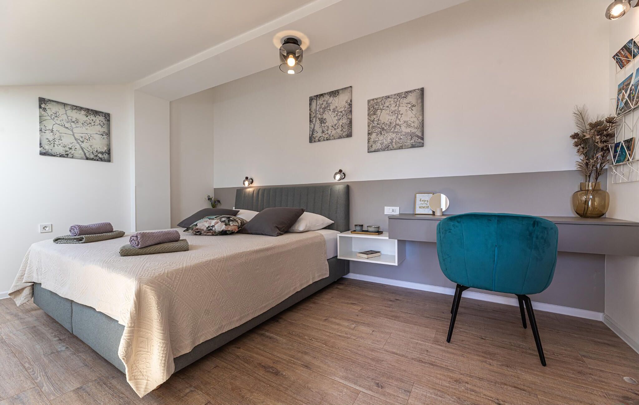 Une chambre moderne avec un lit, une table de chevet et un bureau avec une chaise.