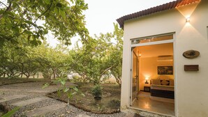 A modern building with a glass door entrance, a small outdoor seating area with a table and chairs, and a garden with a pathway leading to the entrance. - The Rann Baagh Ranthambore (Sawai Madhopur)