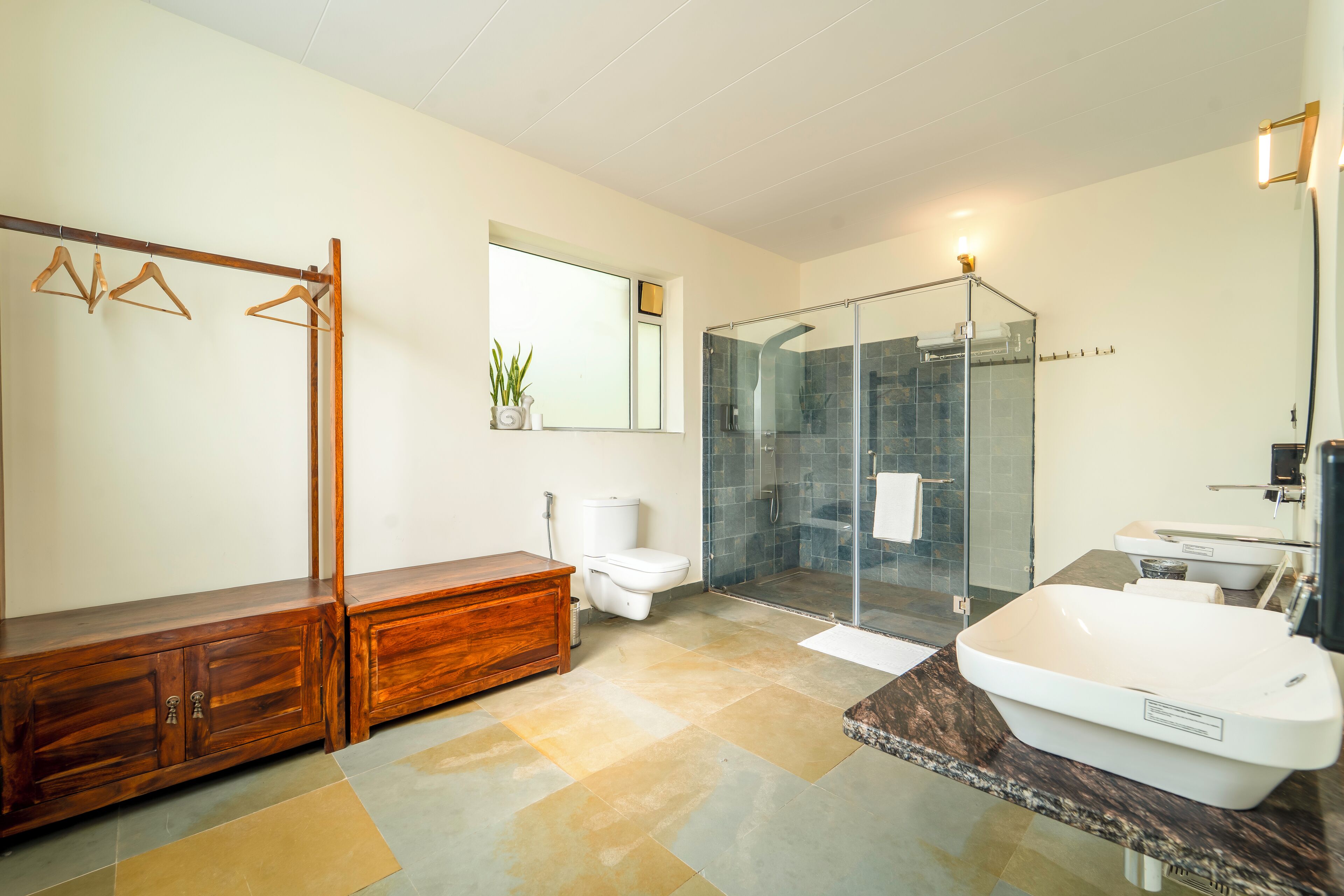 Un bagno moderno con una vasca freestanding, una doccia vetrata, un mobile lavabo in legno e un water.