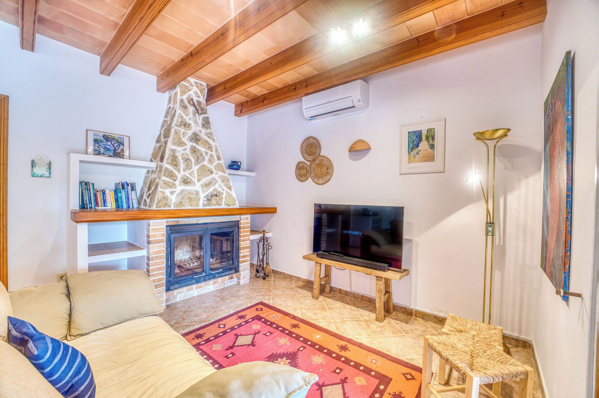 Ein gemütliches Wohnzimmer mit Kamin, Fernseher und bequemer Couch.