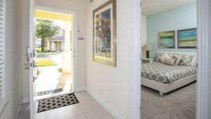 A bedroom with a bed, a nightstand, and a wall-mounted painting.