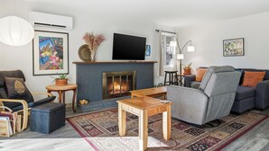 A living room with a fireplace, a sofa, a TV, and a coffee table.