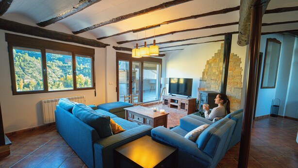 A living room with a sectional sofa, a TV, and a fireplace.