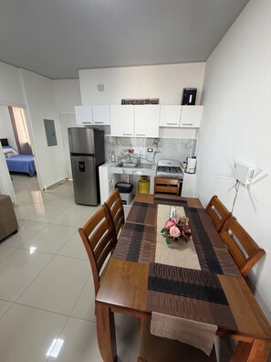 A modern kitchen with white cabinets, a stainless steel refrigerator, and a gas stove.