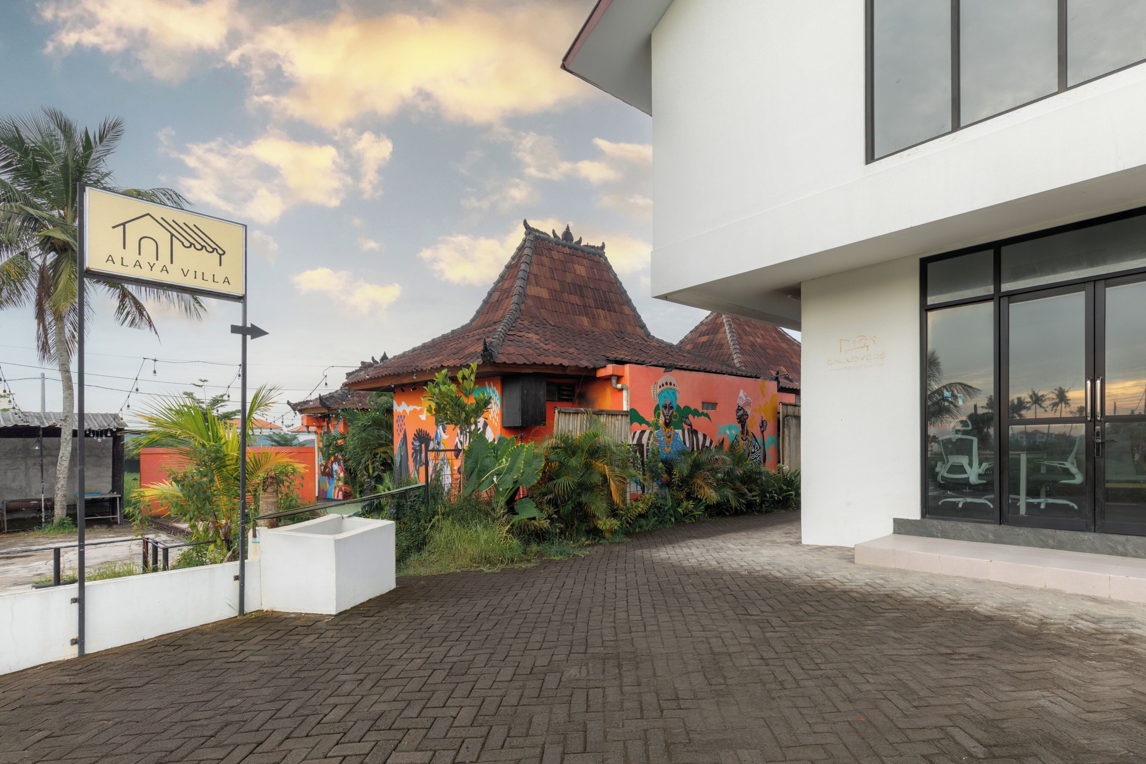 A villa with a traditional tiled roof, a signboard, and a paved walkway.