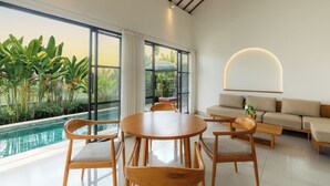 Een moderne woonkamer met uitzicht op een zwembad, houten meubels en een minimalistisch design.