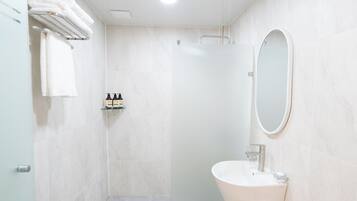 A modern bathroom with a shower, a sink, and a mirror.