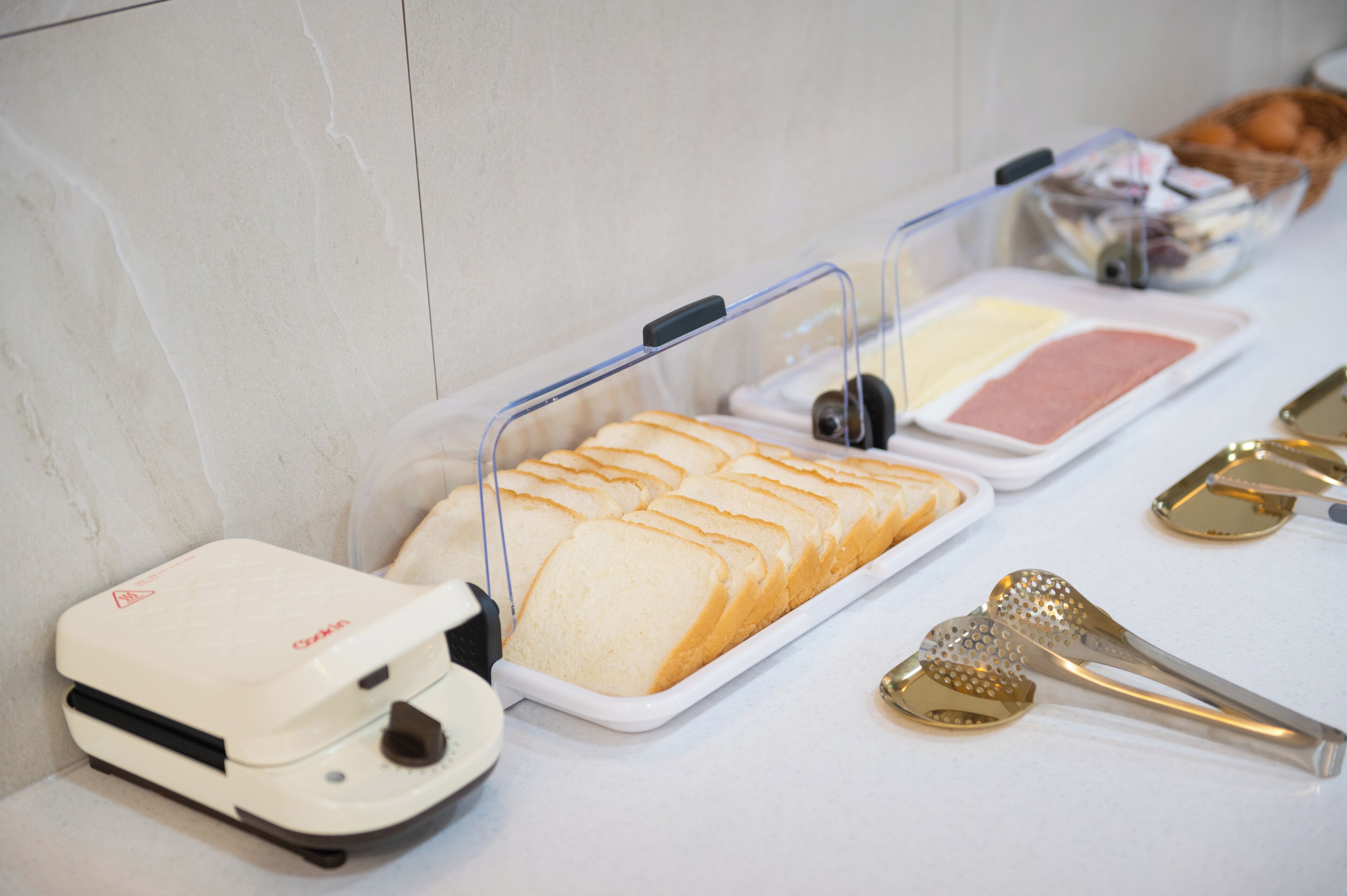 A breakfast buffet with bread, butter, and utensils.