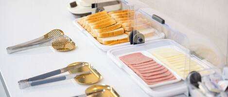 A buffet setup with various food items and utensils.