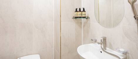 A modern bathroom with a toilet, sink, and shower.
