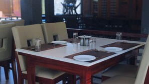 A dining table set with plates, cutlery, and salt and pepper shakers. - Paradise Marari Wellness Resort & Ayurvedic Spa (Ambalapuzha)